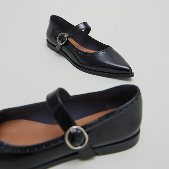 Ballet flats with pointed toes in black glazed leather